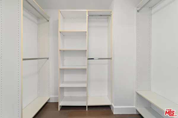 a view of walk in closet with empty racks