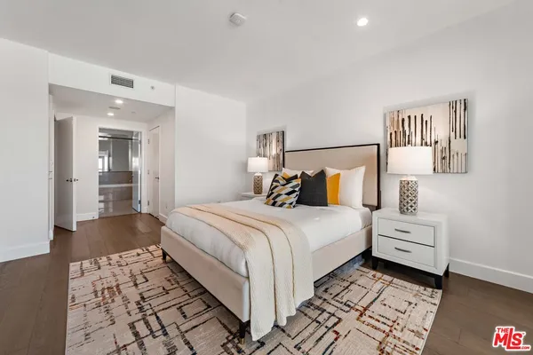 a bedroom with a bed and a lamp on dresser