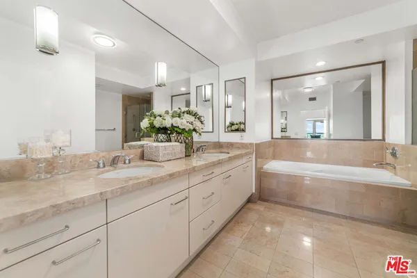 a bathroom with a granite countertop sink mirror and bathtub
