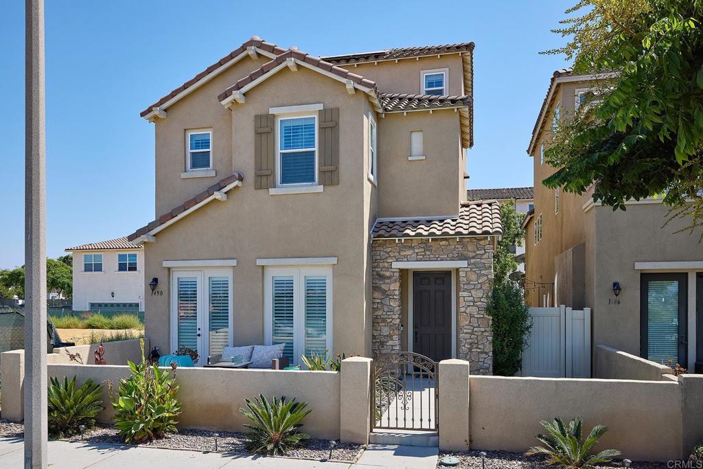 1490 Pershing Road Chula Vista, CA 91913 - Photo 1 of 1 a view of a white house with large windows and a small yard
