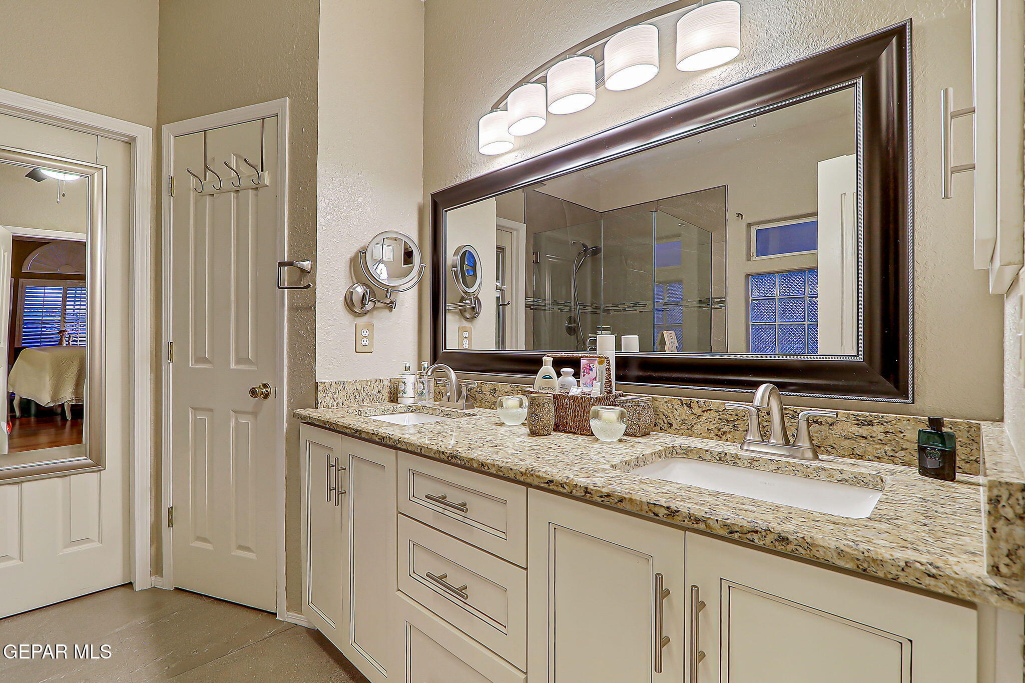 6745 Isla Del Rey Drive El Paso, TX 79912 - Photo 22 of 37 a bathroom with a granite countertop double vanity sink and a mirror