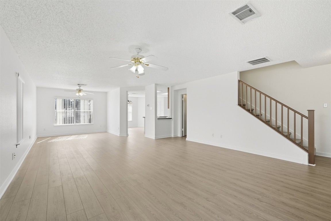 1312 Rosie Lane Cedar Park, TX 78613 - Photo 6 of 38 a view of an empty room with wooden floor and a ceiling fan