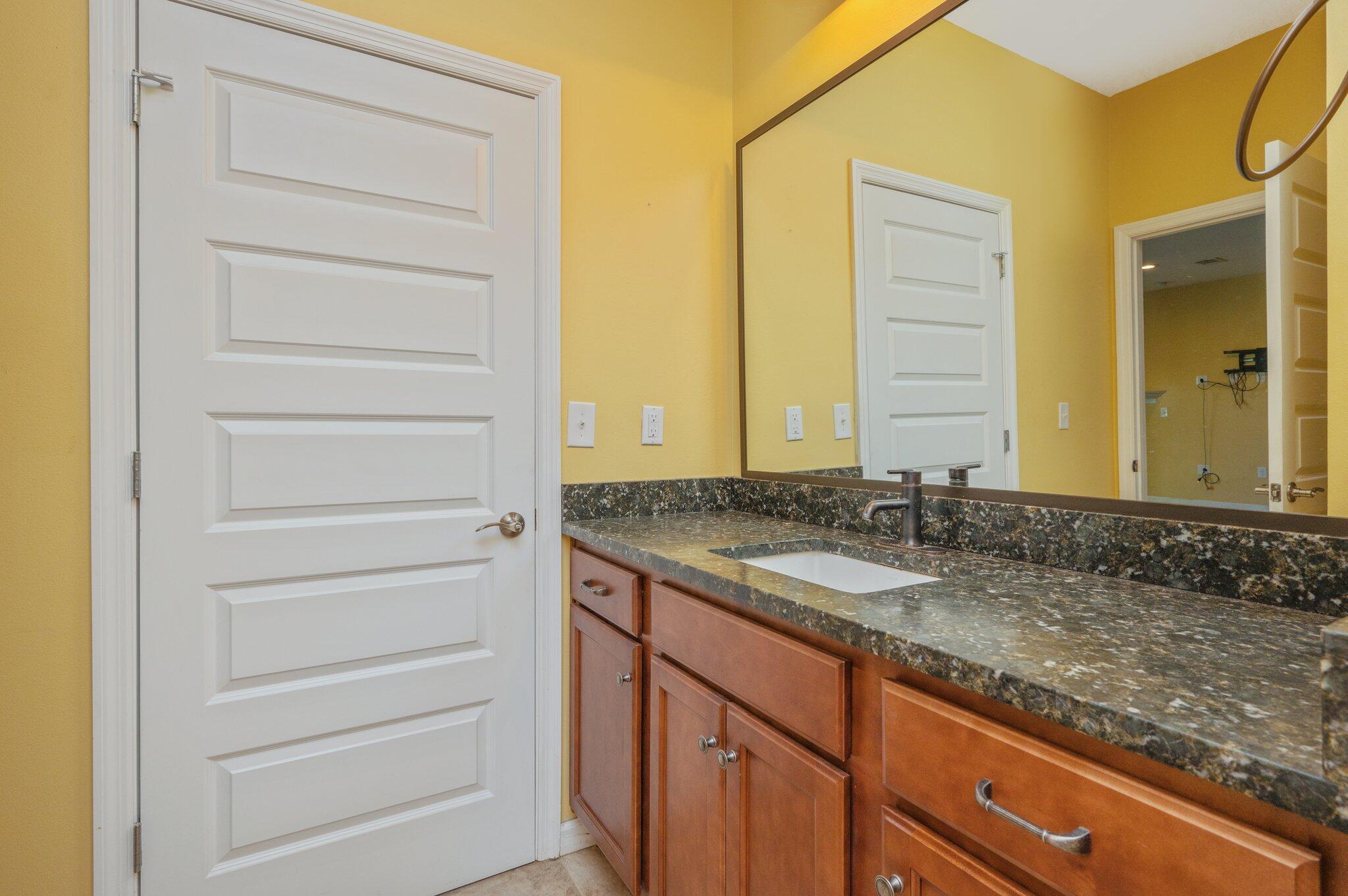 5026 Leitmann Road Baker, FL 32531 - Photo 21 of 65 a bathroom with a granite countertop sink and a mirror