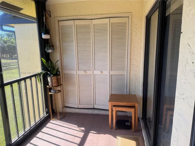 a view of a porch with wooden floor and a floor to ceiling window