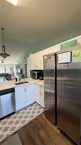 a kitchen with granite countertop white cabinets and white appliances
