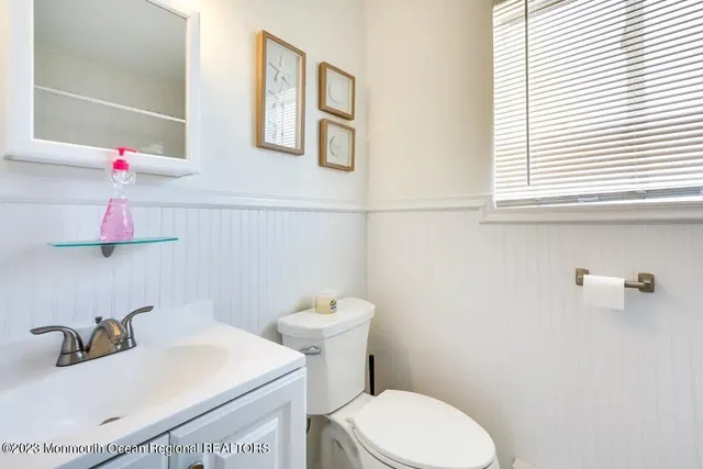 a bathroom with a sink a toilet and a window