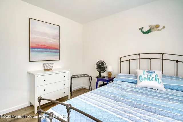 a bedroom with a bed a table and painting on the wall