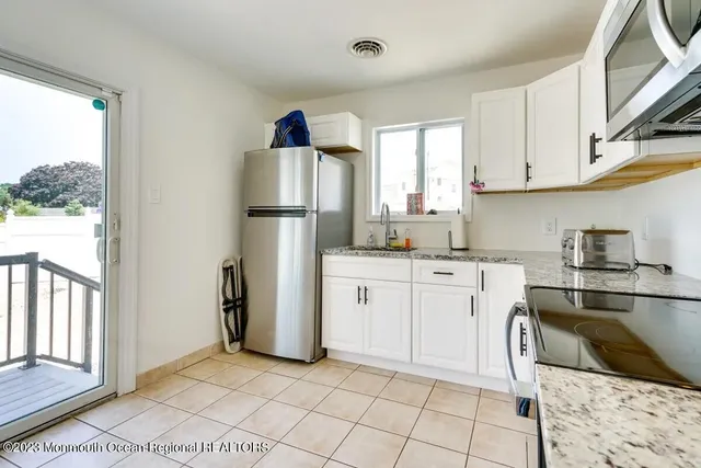 a kitchen with a refrigerator sink and cabinets