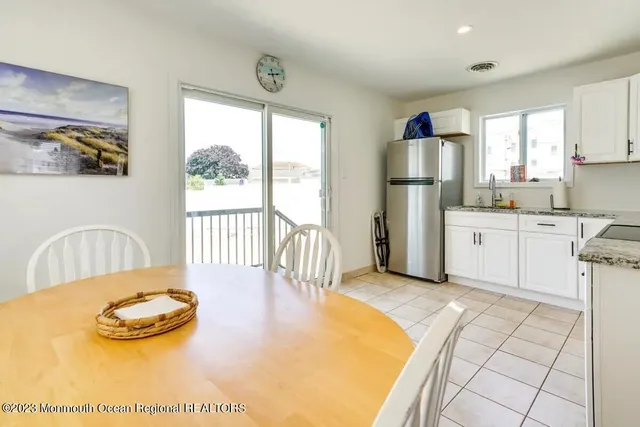 a view of a kitchen with furniture large window and wooden floor