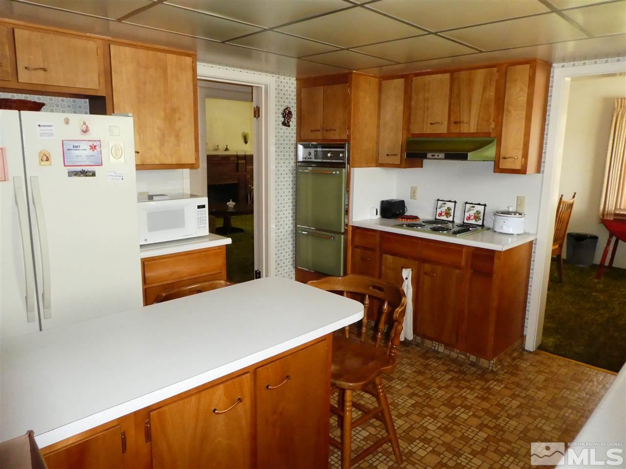 908 Gordon Avenue Reno, NV 89509 - Photo 3 of 12 a kitchen with stainless steel appliances a stove a refrigerator a sink a dining table and chairs