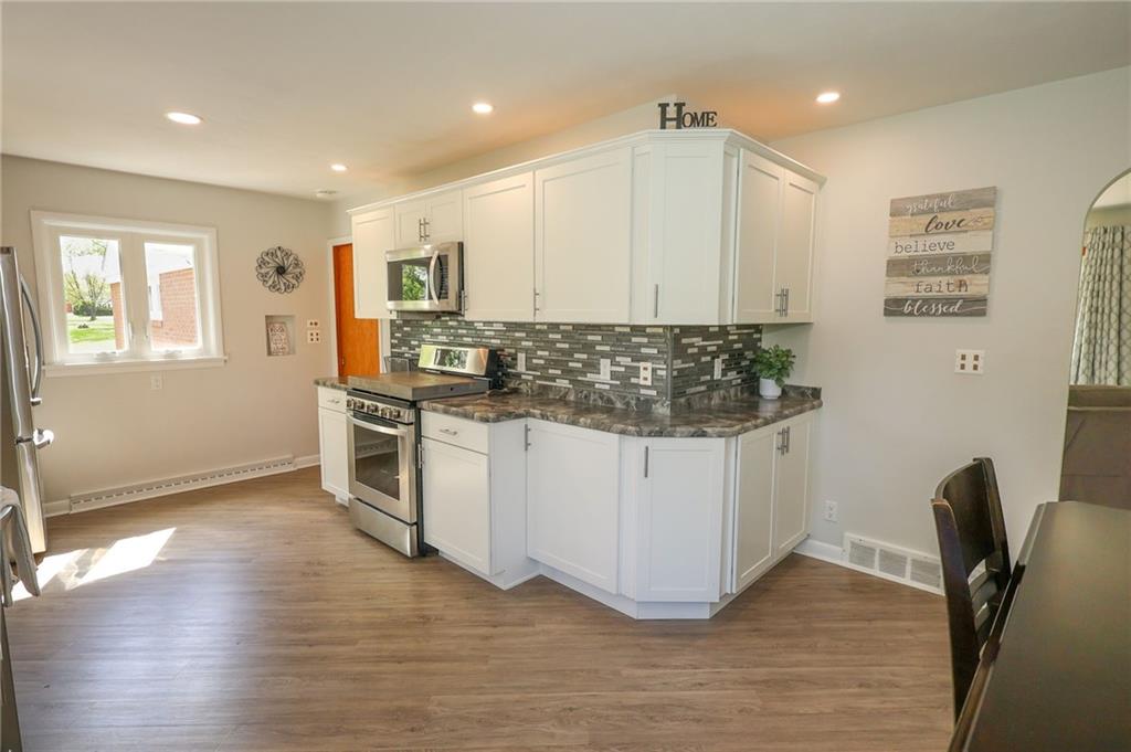 3689 Ridgewood Drive Hermitage, PA 16148 - Photo 11 of 49 a kitchen with stainless steel appliances a stove a sink white cabinets and wooden floor