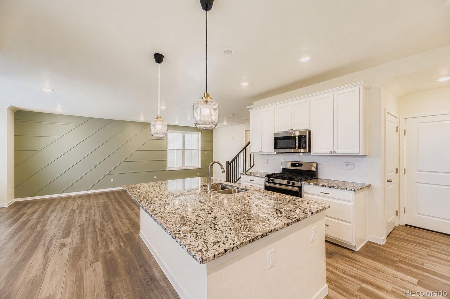 1173 Williams Loop Elizabeth, CO 80107 - Photo 9 of 30 a kitchen with stainless steel appliances granite countertop a sink a stove top oven a counter space and cabinets