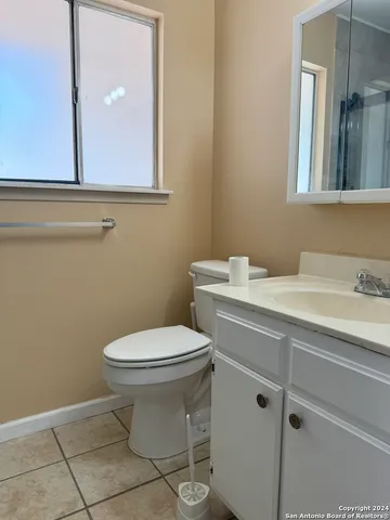 a bathroom with a toilet sink and mirror
