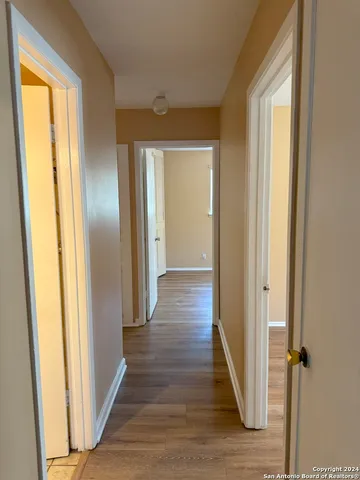 a view of a hallway with wooden floor