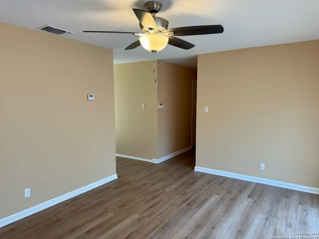 a view of an empty room with wooden floor