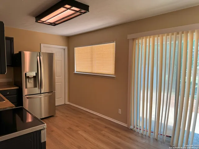 a kitchen with stainless steel appliances a refrigerator and wooden floor