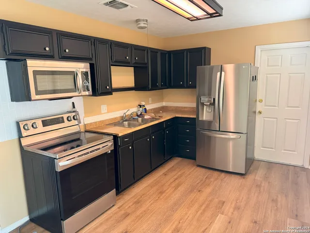 a kitchen with stainless steel appliances a refrigerator stove and sink