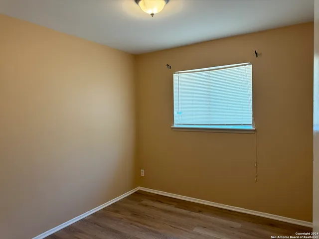 a view of a small space with wooden floor and a window