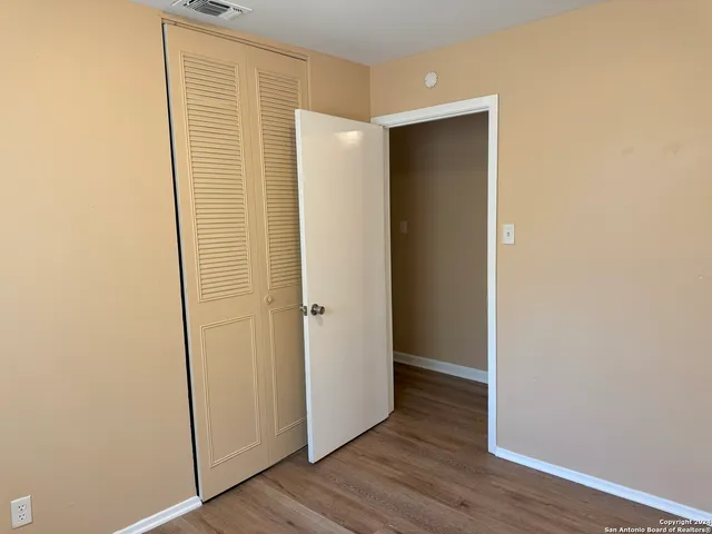 a view of an empty room with wooden floor