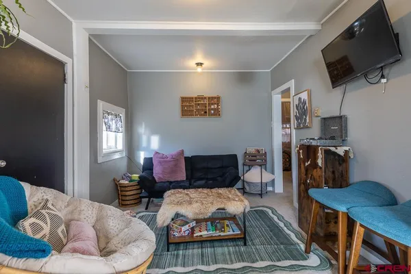 a living room with furniture a window and wooden floor