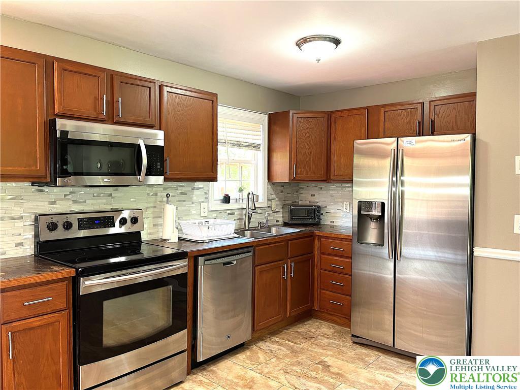 1646 Clover Road Long Pond, PA 18334 - Photo 5 of 24 Rich wood cabinetry pairs with modern stainless steel appliances in this fully functional kitchen.