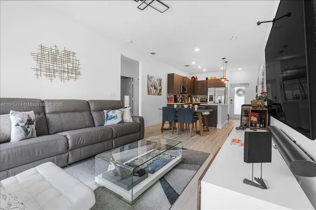 a living room with furniture and a view of kitchen
