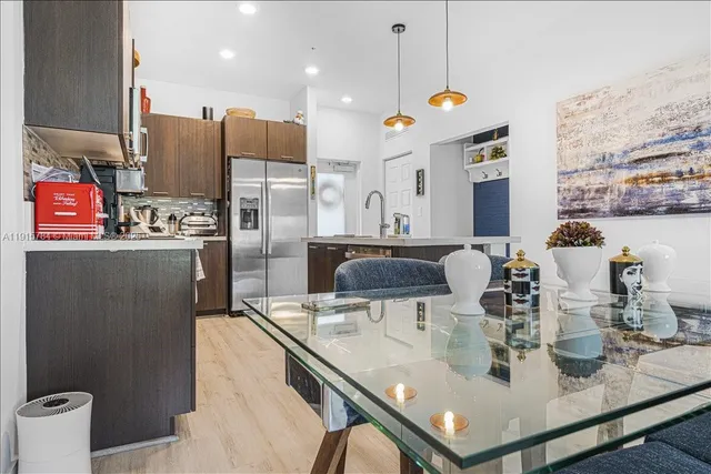 a kitchen with stainless steel appliances granite countertop a sink refrigerator and cabinets