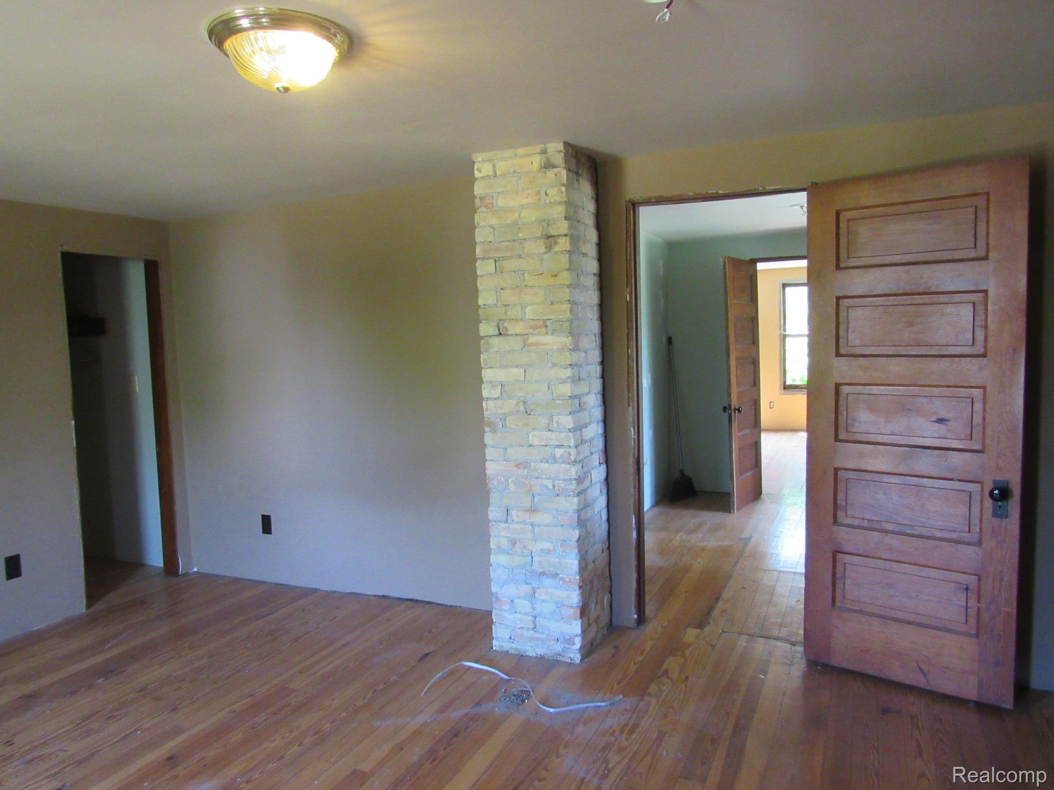 695 Cass Avenue Road Bay City, MI 48708 - Photo 20 of 52 Wood-finish flooring with a brick column accent