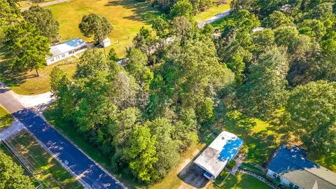 a aerial view of a residential houses with yard and swimming pool