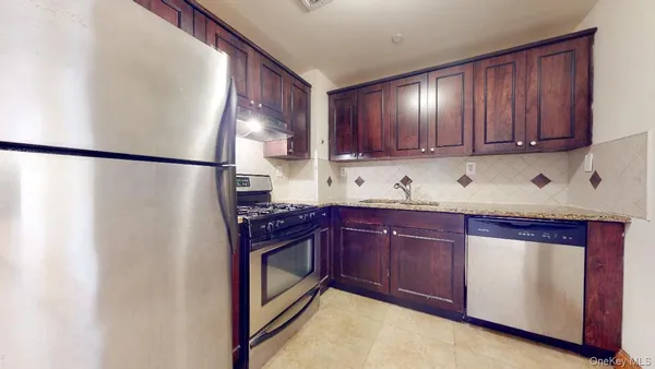a kitchen with stainless steel appliances granite countertop a refrigerator a sink and dishwasher