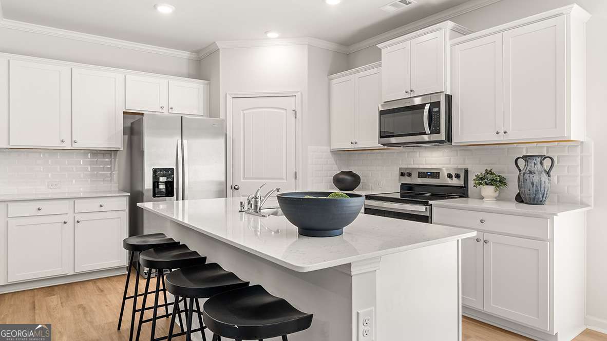 a kitchen with stainless steel appliances a stove a sink a microwave and cabinets