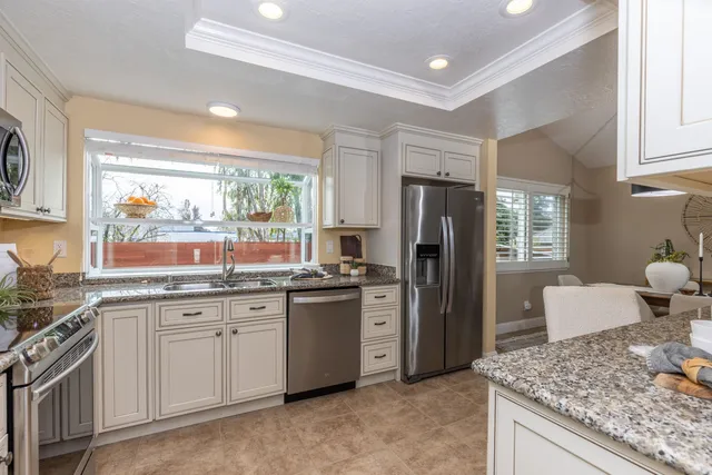 a kitchen with stainless steel appliances granite countertop a refrigerator and a sink