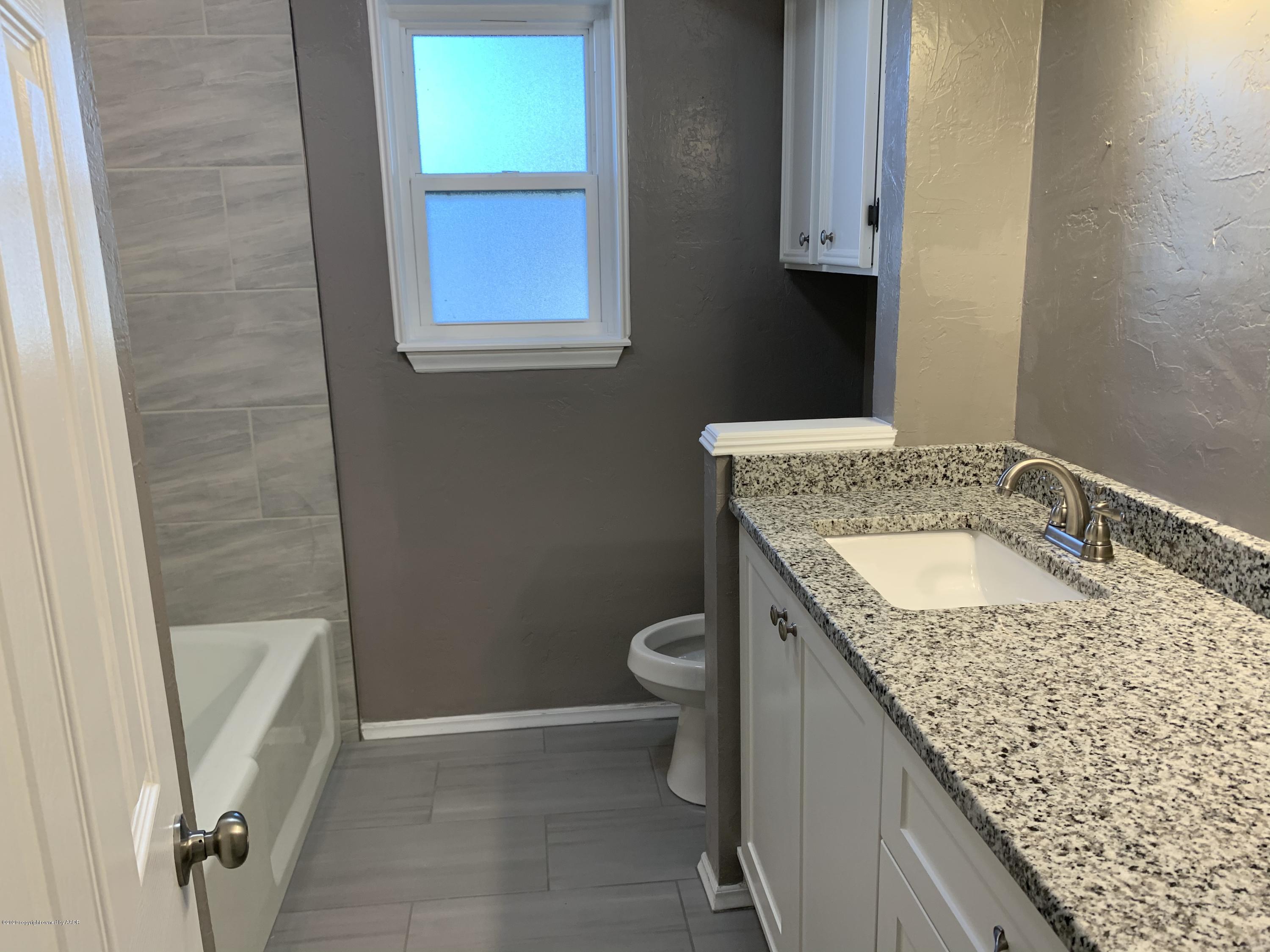 6905 Dreyfuss Road Amarillo, TX 79106 - Photo 14 of 19 a bathroom with a granite countertop sink toilet and a mirror