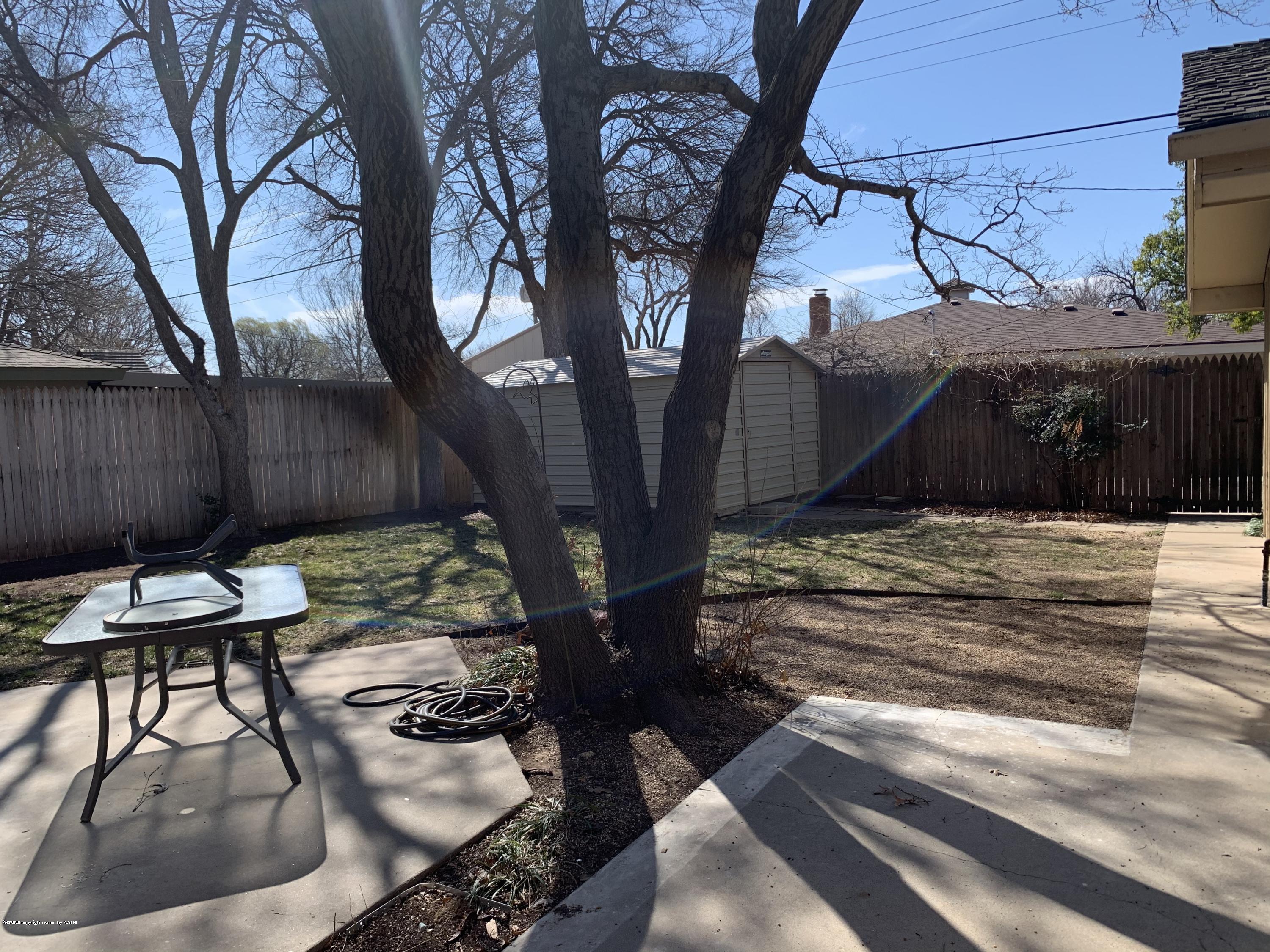 6905 Dreyfuss Road Amarillo, TX 79106 - Photo 19 of 19 a view of a backyard with table and chairs with wooden fence and plants