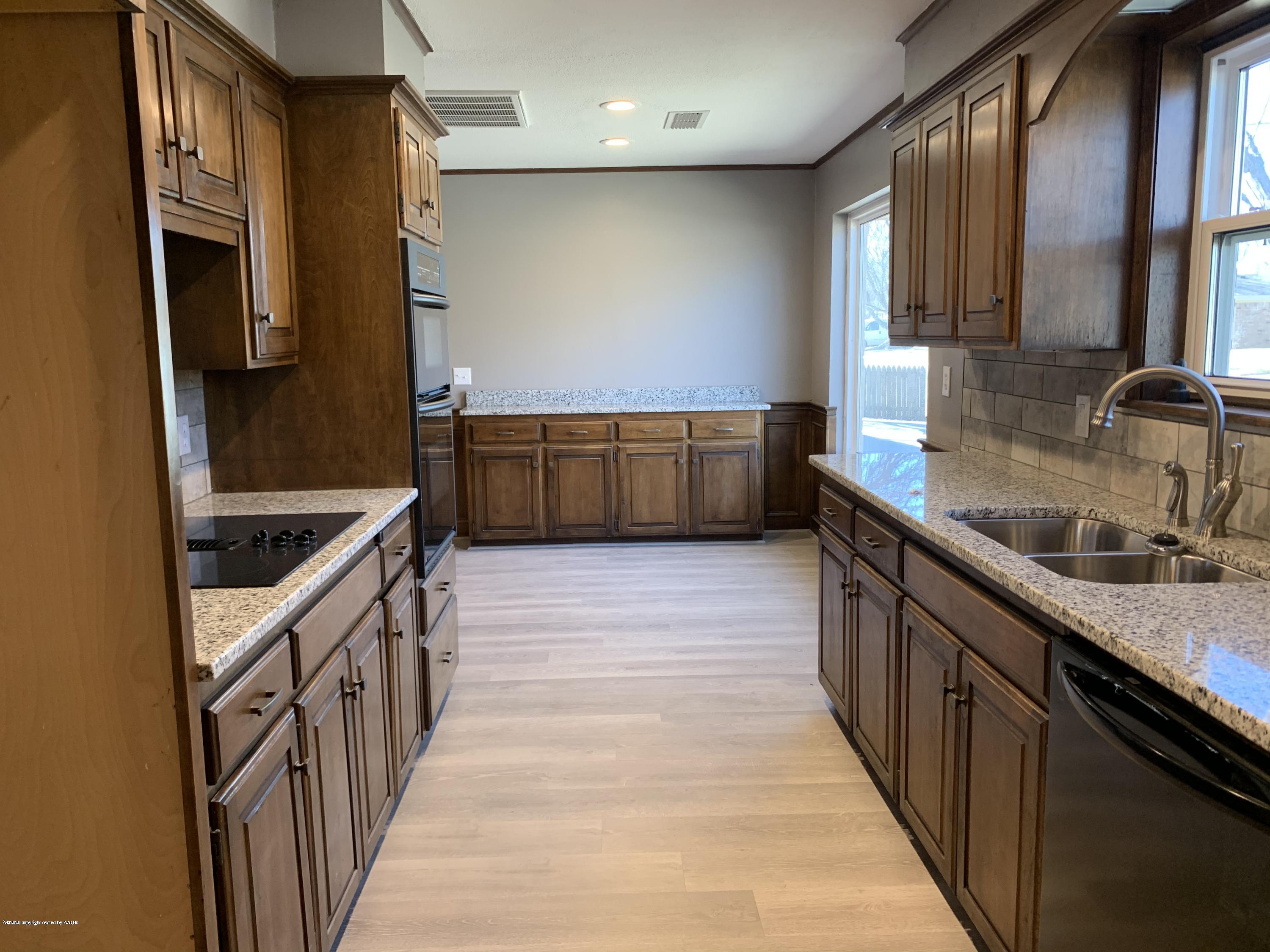 6905 Dreyfuss Road Amarillo, TX 79106 - Photo 6 of 19 a kitchen with stainless steel appliances granite countertop a sink and a stove top oven