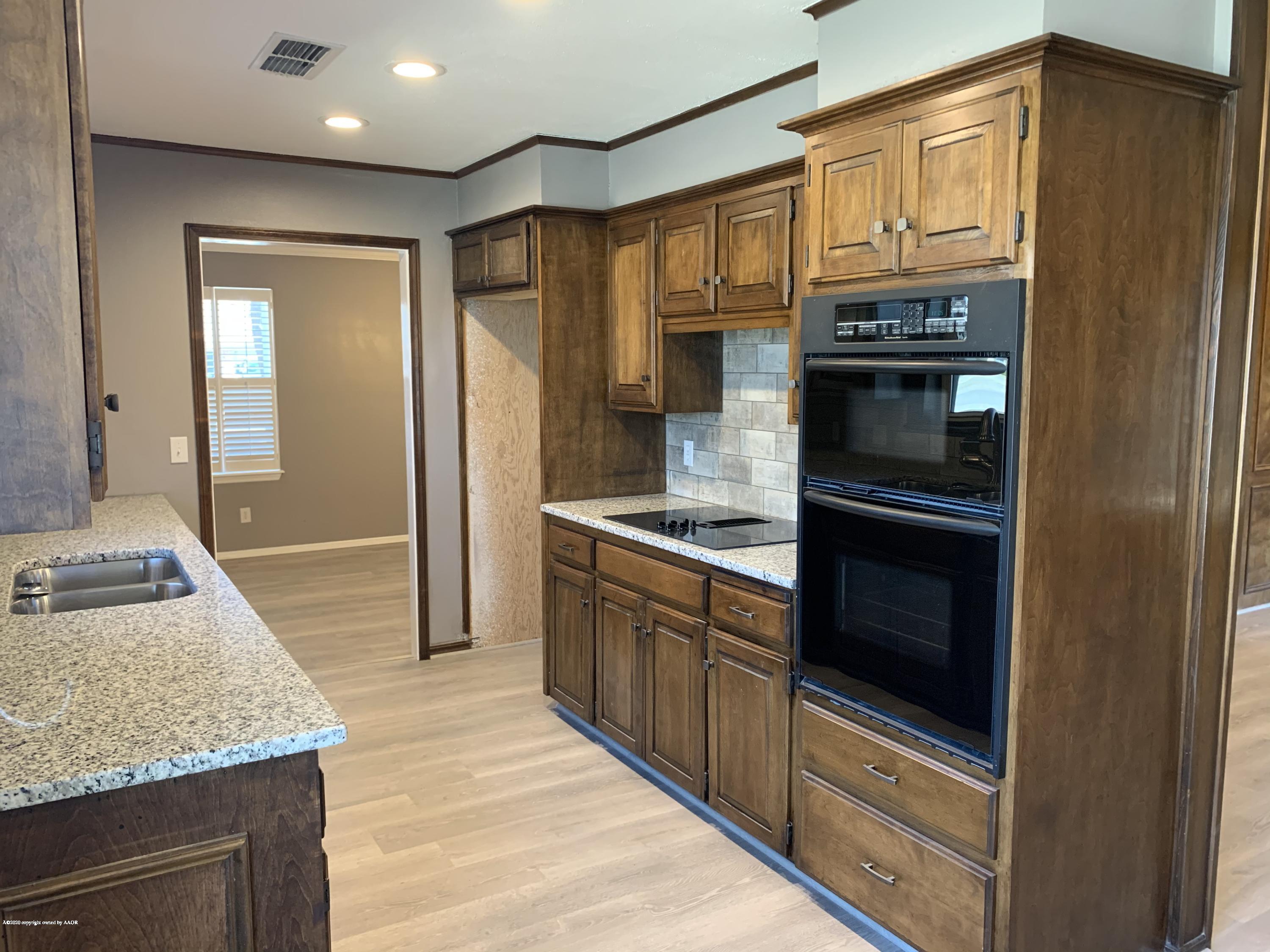 6905 Dreyfuss Road Amarillo, TX 79106 - Photo 7 of 19 a kitchen with stainless steel appliances granite countertop a refrigerator and a sink