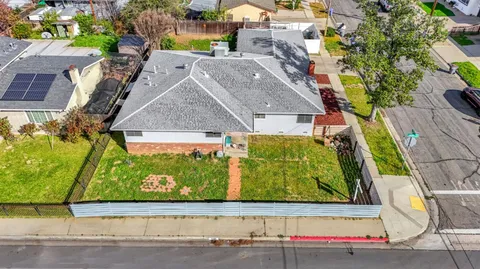 an aerial view of a residential houses with yard