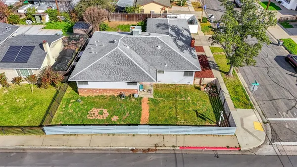 an aerial view of a residential houses with yard