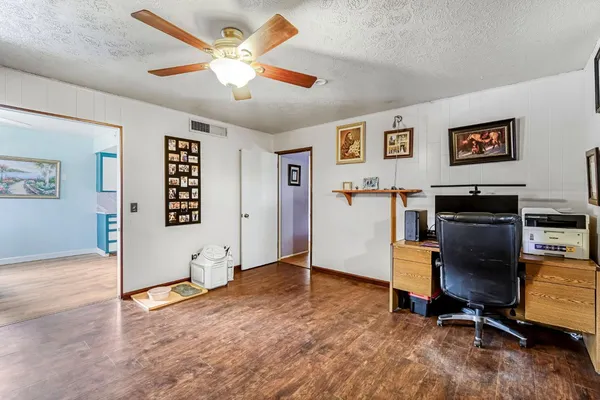 a view of a livingroom with a fireplace a ceiling fan a fireplace a ceiling fan and a refrigerator