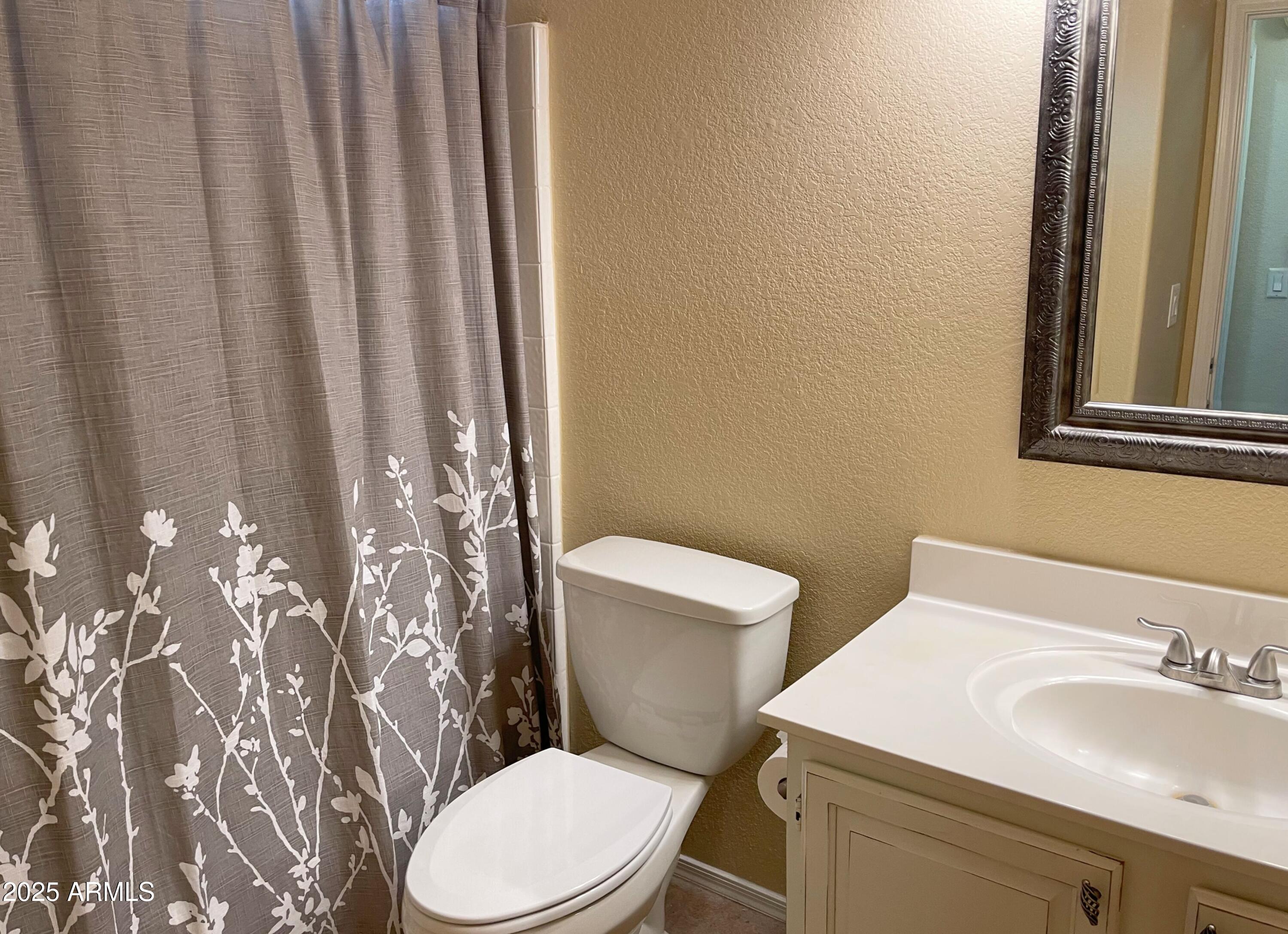 6926 West Via Del Sol Drive Glendale, AZ 85310 - Photo 11 of 18 a white toilet sitting next to a bathroom sink
