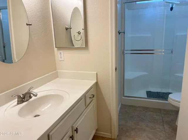 a bathroom with a sink and mirror with toilet