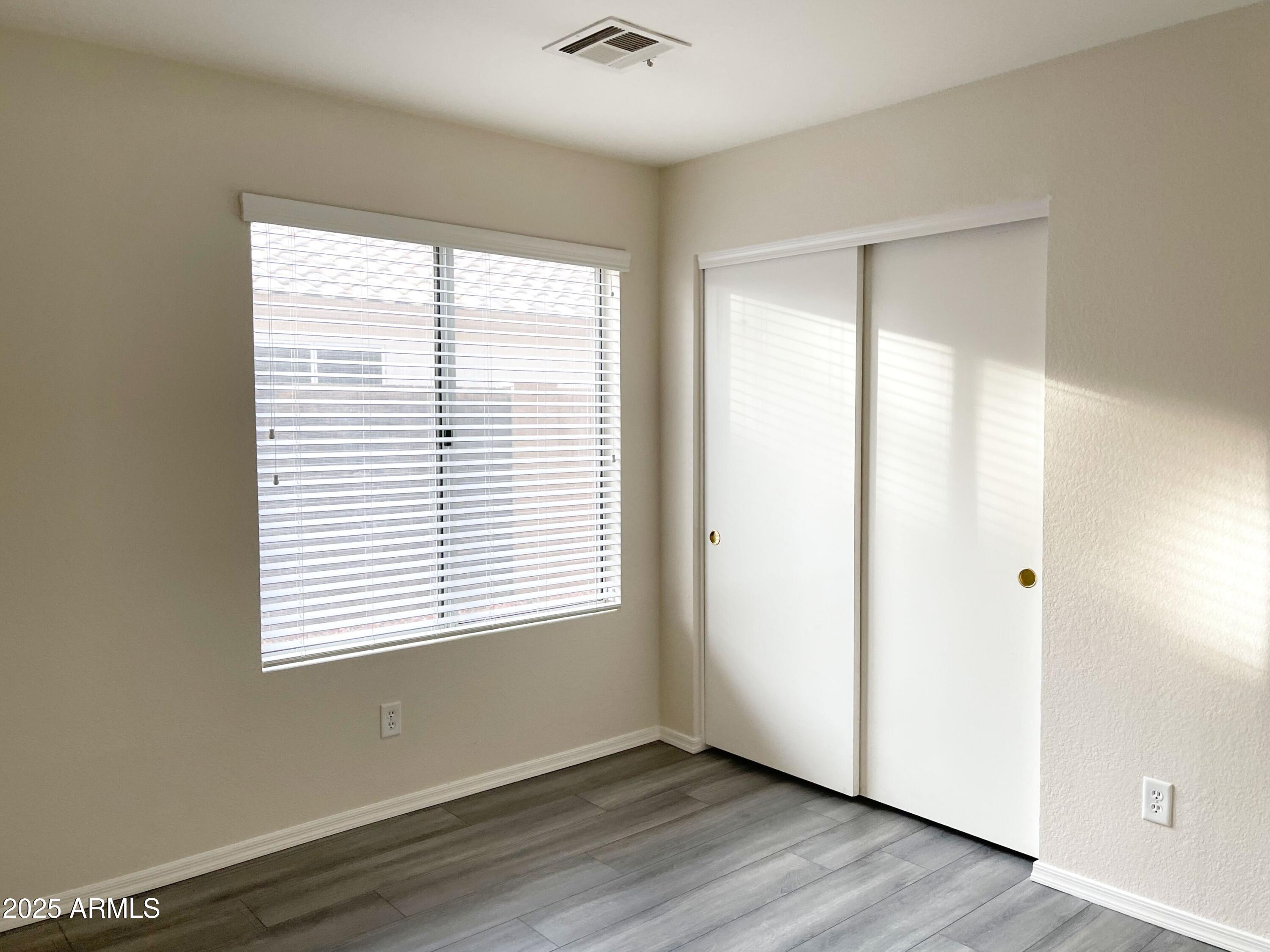 6926 West Via Del Sol Drive Glendale, AZ 85310 - Photo 10 of 18 a view of an empty room with wooden floor and a window