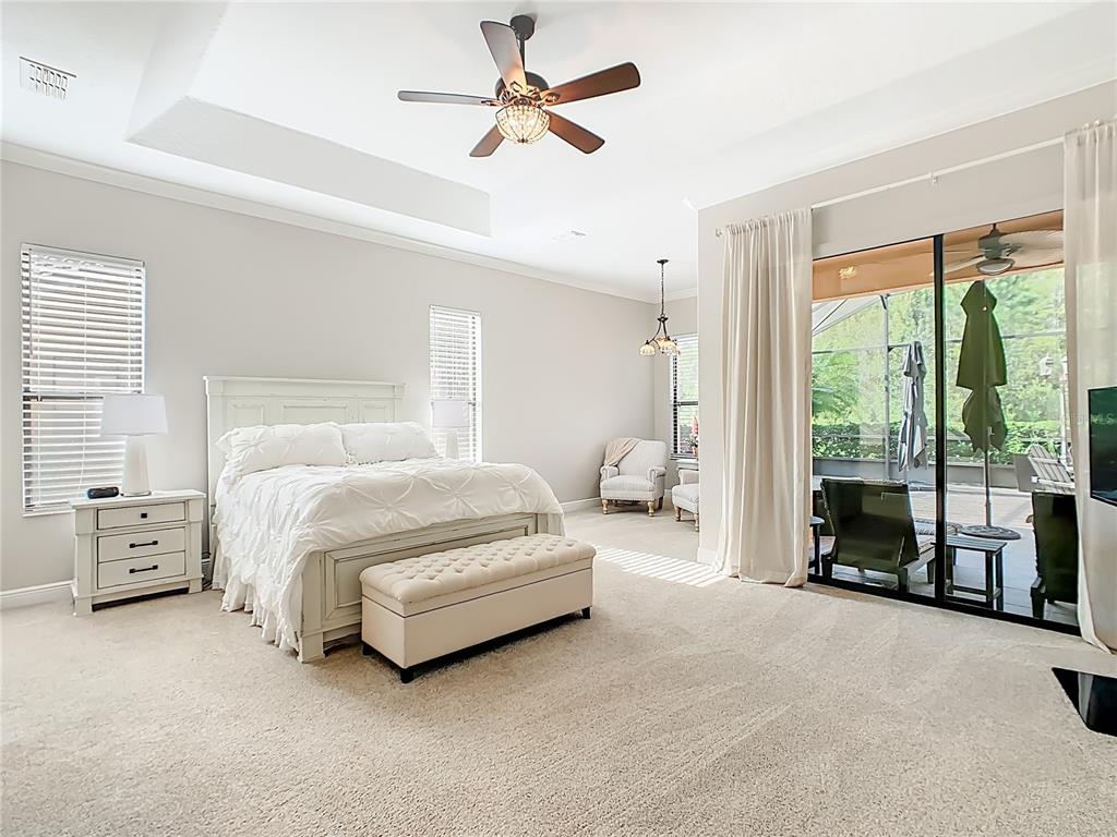 915 San Raphael Street Poinciana, FL 34759 - Photo 22 of 84 a spacious bedroom with a bed and a chandelier