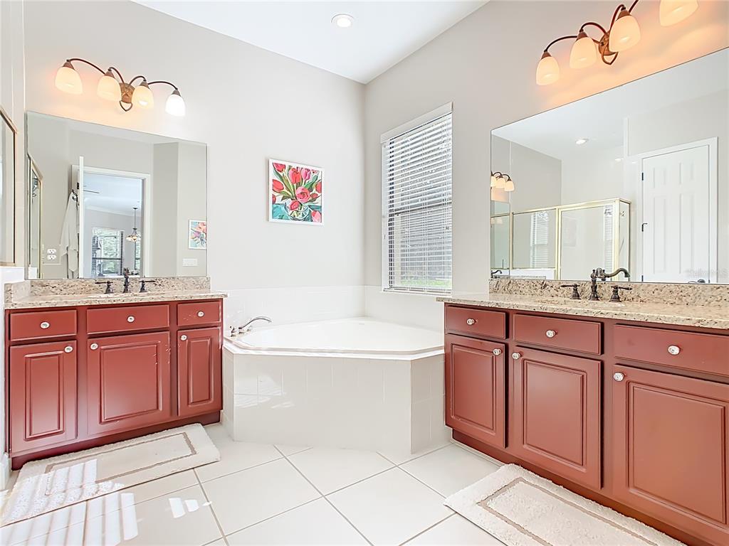 915 San Raphael Street Poinciana, FL 34759 - Photo 26 of 84 a spacious bathroom with a granite countertop sink and a mirror