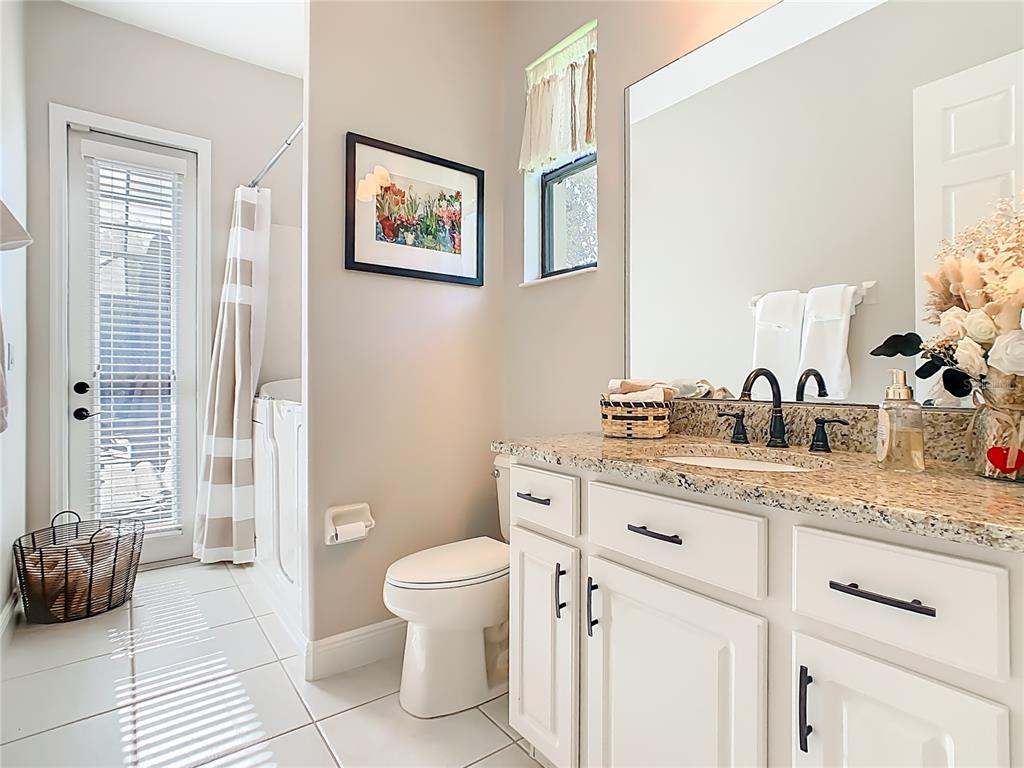 915 San Raphael Street Poinciana, FL 34759 - Photo 32 of 84 a spacious bathroom with a granite countertop sink mirror and toilet