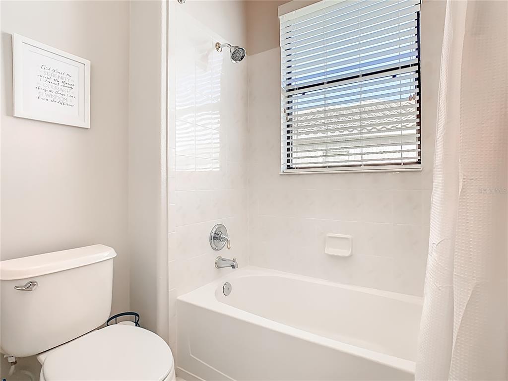 915 San Raphael Street Poinciana, FL 34759 - Photo 40 of 84 a white toilet sitting next to a bath tub