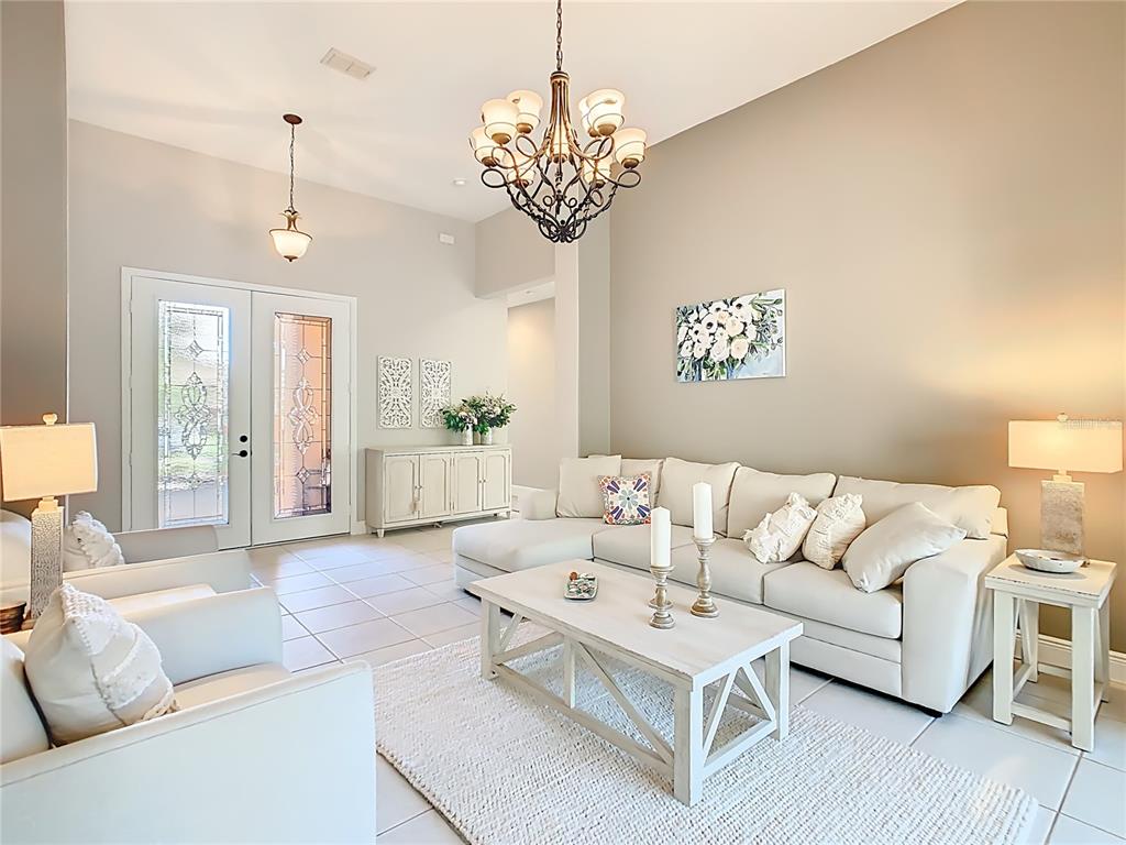 915 San Raphael Street Poinciana, FL 34759 - Photo 7 of 84 a living room with furniture a chandelier and a chandelier
