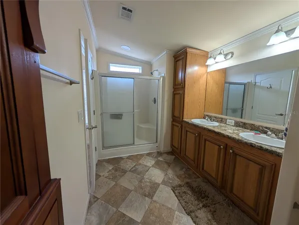 a bathroom with a glass shower door and a sink