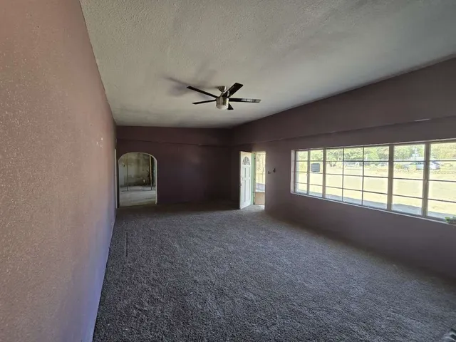a view of a livingroom with a ceiling fan and window