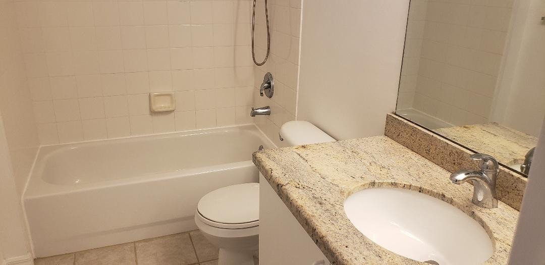 5011 Wiles Road, Unit 301 Coconut Creek, FL 33073 - Photo 13 of 16 a bathroom with a granite countertop toilet sink and bathtub